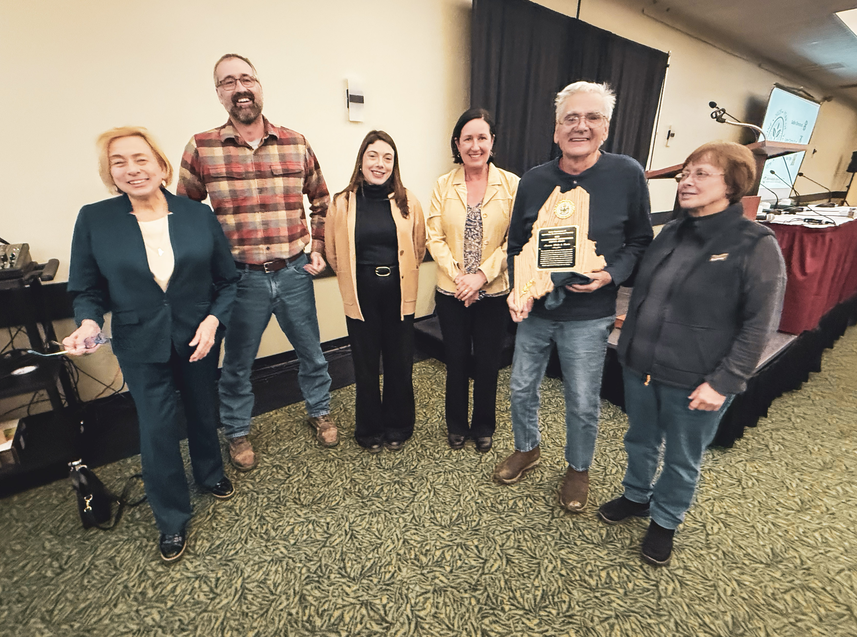 Award presentation at the Commissioner's Luncheon on day one of the Maine Agricultural Trades Show. Pictured left to right: Maine Governor Janet Mills, Marcus Flewelling, Sara Williams Flewelling, DACF Commissioner Amanda Beal, and Matt and Linda Williams.